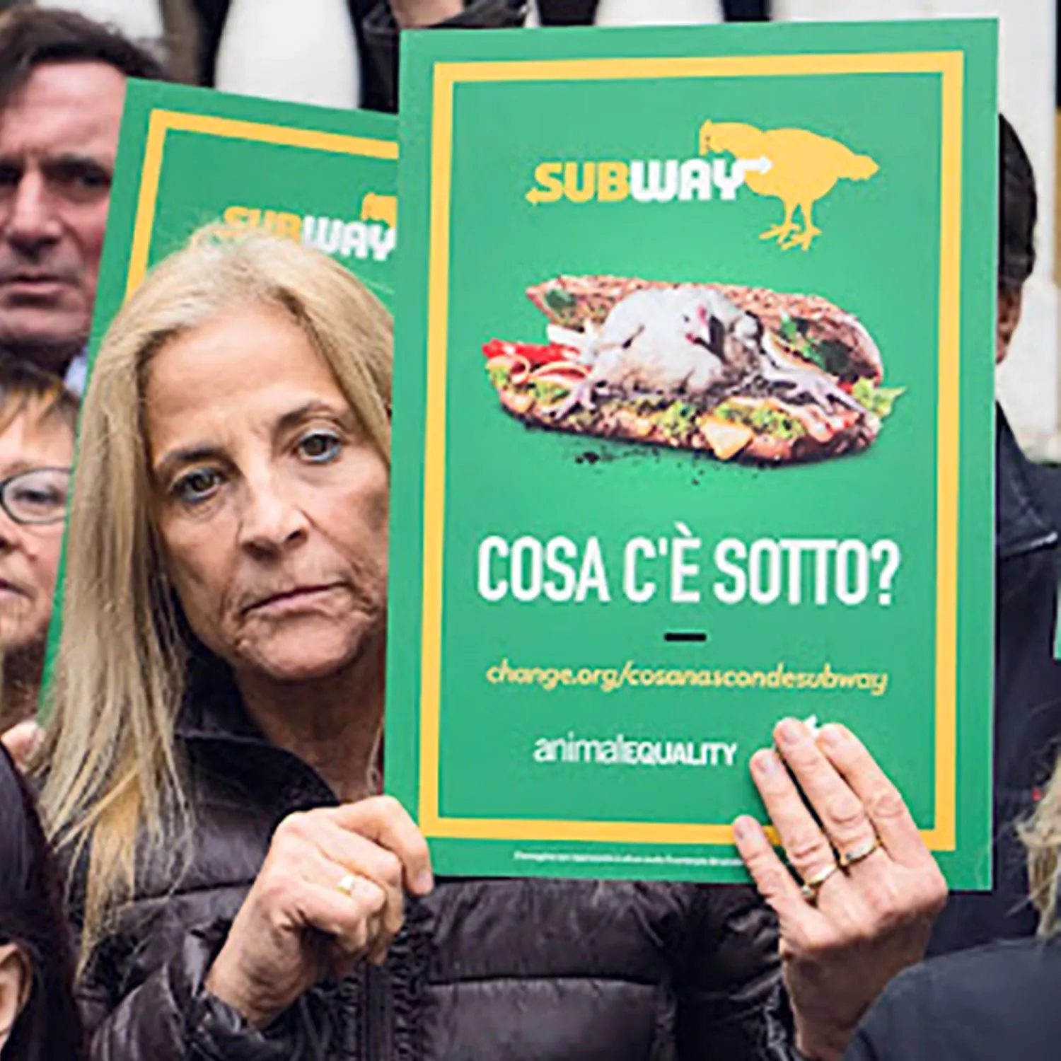 woman holding a sign at a Subway protest